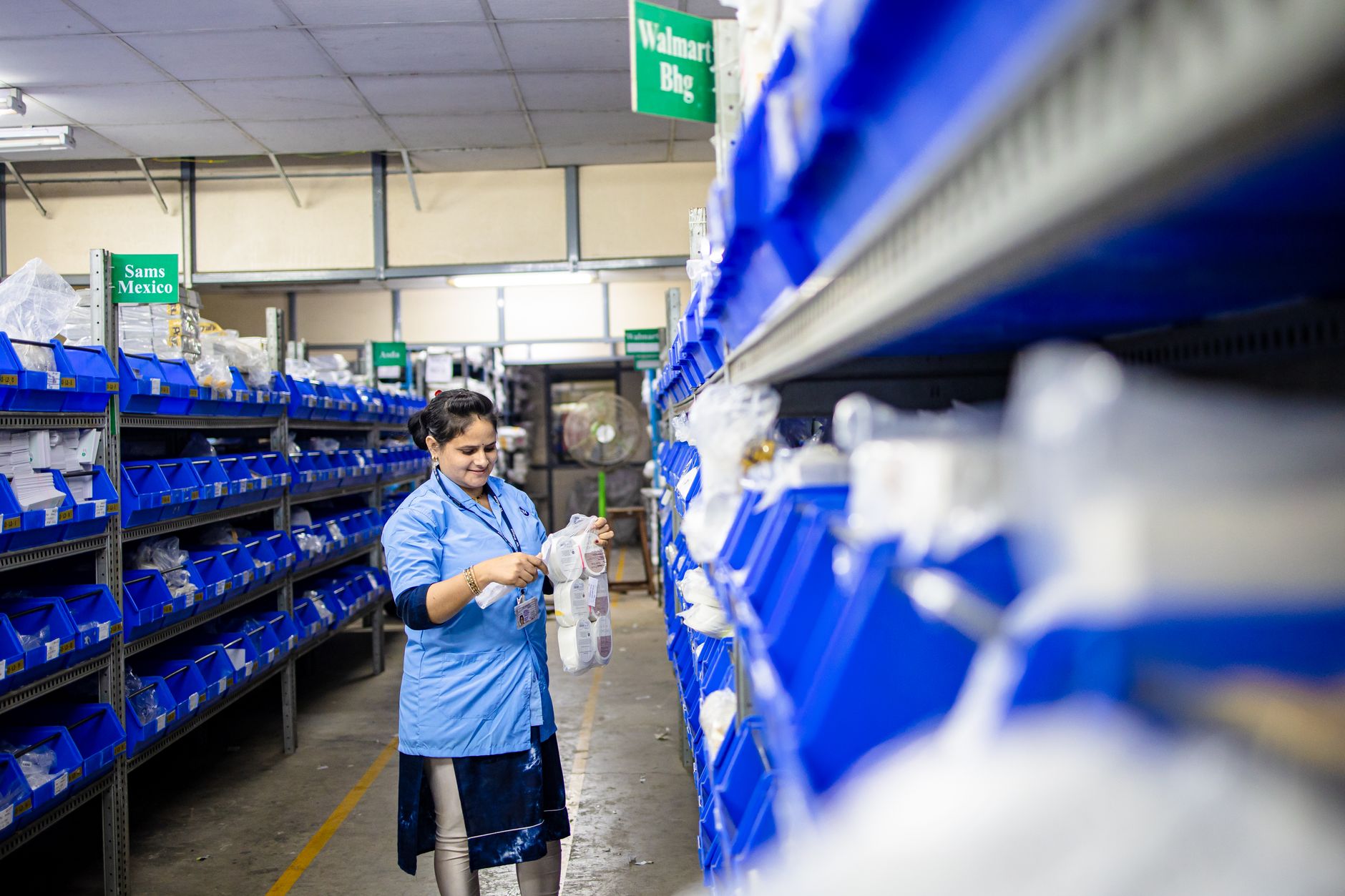 Worker standing in an aisle of parts shelves